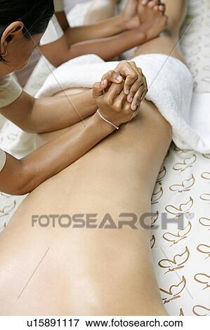 A woman having massage by masseuses. View Large Photo Image Stock Photo - A woman having massage by masseuses.. Fotosearch