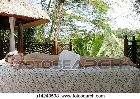 A young topless woman lying on massage table. View Large Photo Image Stock Photo - A young topless woman lying on massage table.. Fotosearch