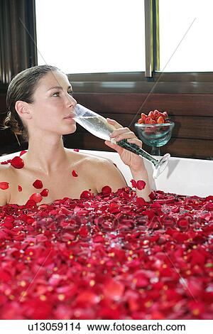A young woman drinking while having aromatherapy bath. View Large Photo Image Picture - A young woman drinking while having aromatherapy bath.. Fotosearch