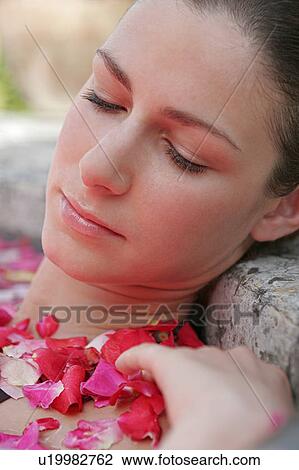 Stock Image - Close-up of a woman having aromatherapy bath.. Fotosearch