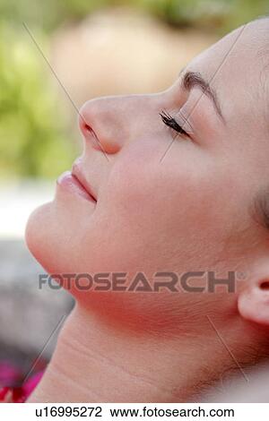 Stock Image - Close-up of a young woman with eyes closed.. Fotosearch