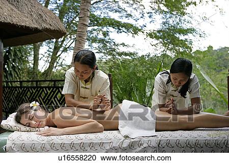 Two masseuses massaging a woman’s body. View Large Photo Image Stock Image - Two masseuses massaging a woman’s body.. Fotosearch