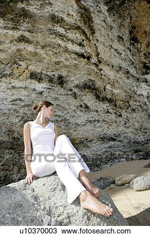 A woman sitting on a rock. View Large Photo Image Stock Image - A woman sitting on a rock.. Fotosearch