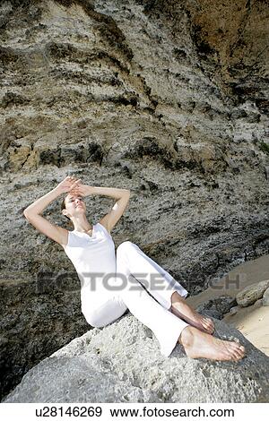A woman sitting on a rock. View Large Photo Image Stock Photo - A woman sitting on a rock.. Fotosearch