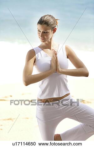 A woman standing with joined hands on a beach. View Large Photo Image Stock Image - A woman standing with joined hands on a beach.. Fotosearch