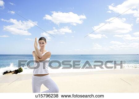 A young woman exercising on a beach. View Large Photo Image Stock Photo - A young woman exercising on a beach.. Fotosearch