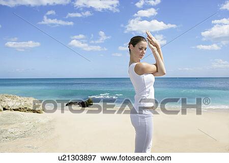 A young woman exercising on a beach. View Large Photo Image Stock Photo - A young woman exercising on a beach.. Fotosearch