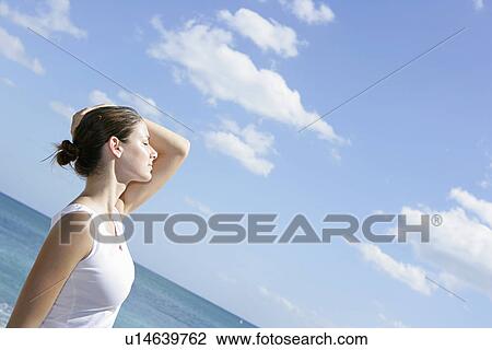 A young woman on a beach with arm raised. View Large Photo Image Stock Image - A young woman on a beach with arm raised.. Fotosearch