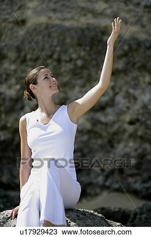 Stock Image - View of a woman sitting on rock.. Fotosearch