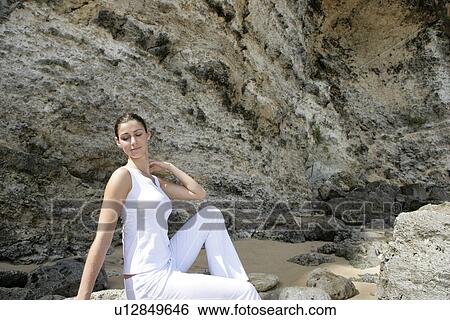 View of a woman sitting on rocks. View Large Photo Image Stock Photograph - View of a woman sitting on rocks.. Fotosearch