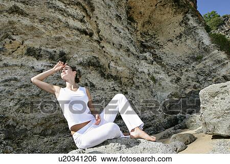 View of a woman sitting on rocks. View Large Photo Image Stock Photograph - View of a woman sitting on rocks.. Fotosearch