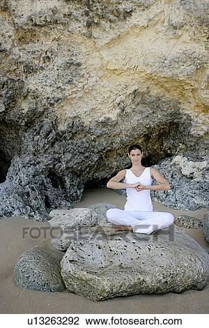 View of a woman sitting with cross legged on a rock. View Large Photo Image Stock Image - View of a woman sitting with cross legged on a rock.. Fotosearch