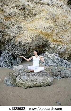 View of a woman sitting with cross legged on a rock. View Large Photo Image Stock Image - View of a woman sitting with cross legged on a rock.. Fotosearch