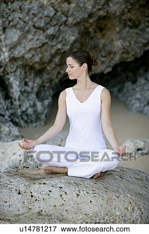 View of a woman sitting with cross legged on a rock. View Large Photo Image Stock Photo - View of a woman sitting with cross legged on a rock.. Fotosearch