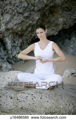View of a woman sitting with cross legged on a rock. View Large Photo Image Stock Photography - View of a woman sitting with cross legged on a rock.. Fotosearch