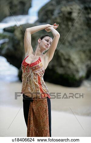View of a woman standing on a beach. View Large Photo Image Picture - View of a woman standing on a beach.. Fotosearch