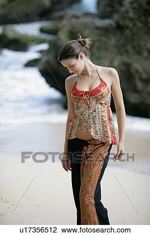 Stock Image - View of a woman standing on a beach.. Fotosearch