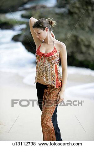 View of a woman standing on a beach. View Large Photo Image Stock Photo - View of a woman standing on a beach.. Fotosearch