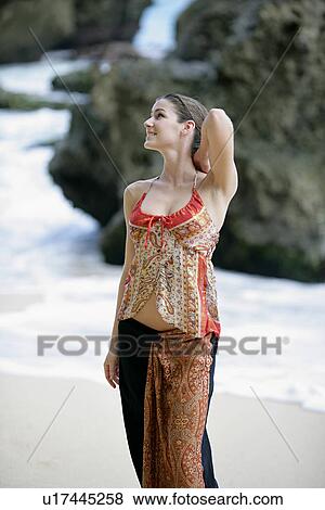 Stock Photo - View of a woman standing on a beach.. Fotosearch