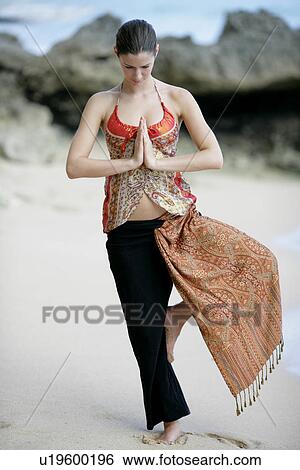 Stock Photograph - View of a woman standing with joined hands.. Fotosearch