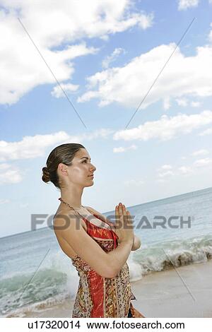 View of a woman with joined hands on a beach. View Large Photo Image Picture - View of a woman with joined hands on a beach.. Fotosearch