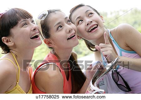 Stock Photography - View of young women looking up.. Fotosearch