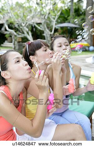 View of young women blowing bubbles. View Large Photo Image Stock Photo - View of young women blowing bubbles.. Fotosearch