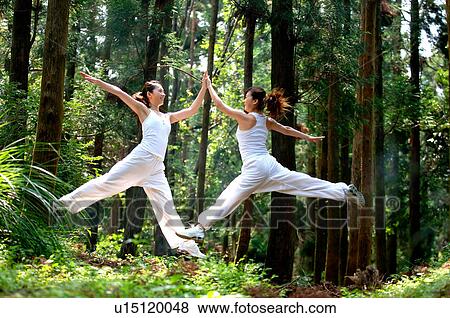 View of young women exercising in a forest. View Large Photo Image Stock Photo - View of young women exercising in a forest.. Fotosearch