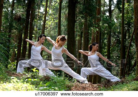 Stock Photo - View of young women exercising in a forest.. Fotosearch