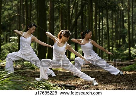 Stock Photo - View of young women exercising in a forest.. Fotosearch