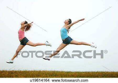 View of young women exercising on grassland. View Large Photo Image Picture - View of young women exercising on grassland.. Fotosearch