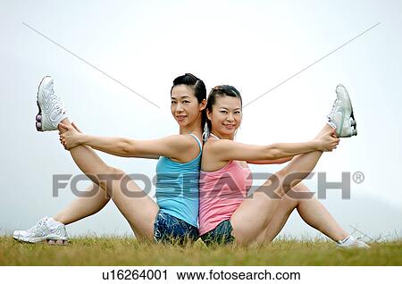 View of young women exercising on grassland. View Large Photo Image Stock Image - View of young women exercising on grassland.. Fotosearch