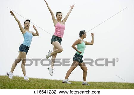 View of young women exercising on grassland. View Large Photo Image Stock Image - View of young women exercising on grassland.. Fotosearch