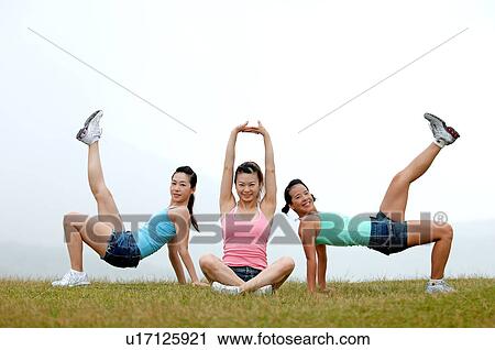 View of young women exercising on grassland. View Large Photo Image Stock Image - View of young women exercising on grassland.. Fotosearch