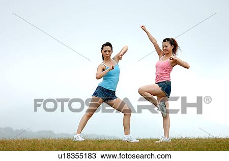 View of young women exercising on grassland. View Large Photo Image Stock Image - View of young women exercising on grassland.. Fotosearch