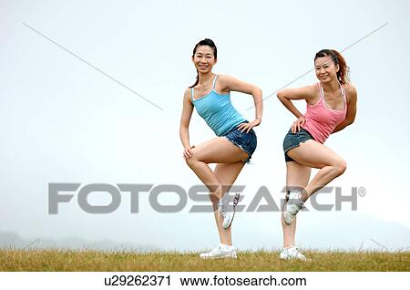 View of young women exercising on grassland. View Large Photo Image Stock Image - View of young women exercising on grassland.. Fotosearch