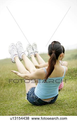 View of young women exercising on grassland. View Large Photo Image Stock Photo - View of young women exercising on grassland.. Fotosearch