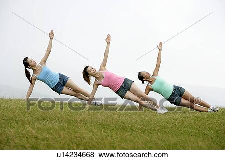 View of young women exercising on grassland. View Large Photo Image Stock Photo - View of young women exercising on grassland.. Fotosearch