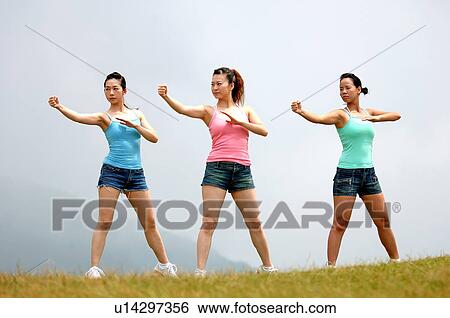 View of young women exercising on grassland. View Large Photo Image Stock Photograph - View of young women exercising on grassland.. Fotosearch
