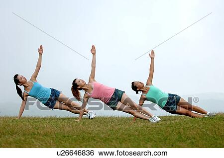 View of young women exercising on grassland. View Large Photo Image Stock Photograph - View of young women exercising on grassland.. Fotosearch
