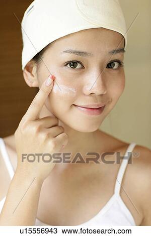 View of a woman applying a lotion on face. View Large Photo Image Stock Image - View of a woman applying a lotion on face.. Fotosearch