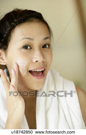 View of a woman applying cream on her face. View Large Photo Image Stock Image - View of a woman applying cream on her face.. Fotosearch