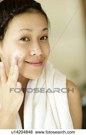View of a woman applying cream on her cheeks. View Large Photo Image Stock Photo - View of a woman applying cream on her cheeks.. Fotosearch