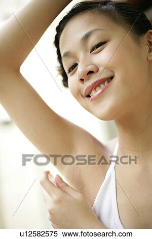 View of a woman applying deodorant. View Large Photo Image Stock Photography - View of a woman applying deodorant.. Fotosearch