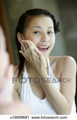 View of a woman applying rouge on her face. View Large Photo Image Stock Image - View of a woman applying rouge on her face.. Fotosearch