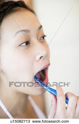 View of a woman brushing her teeth. View Large Photo Image Stock Image - View of a woman brushing her teeth.. Fotosearch