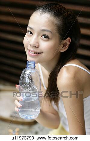 View of a woman holding water bottle. View Large Photo Image Stock Image - View of a woman holding water bottle.. Fotosearch