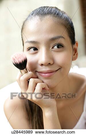 Stock Photo - View of a woman with a brush in her hand.. Fotosearch