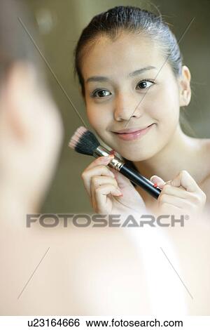 Stock Photograph - View of a woman with a brush in her hand.. Fotosearch