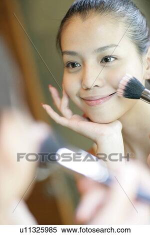 View of a young woman doing makeup. View Large Photo Image Stock Photography - View of a young woman doing makeup.. Fotosearch